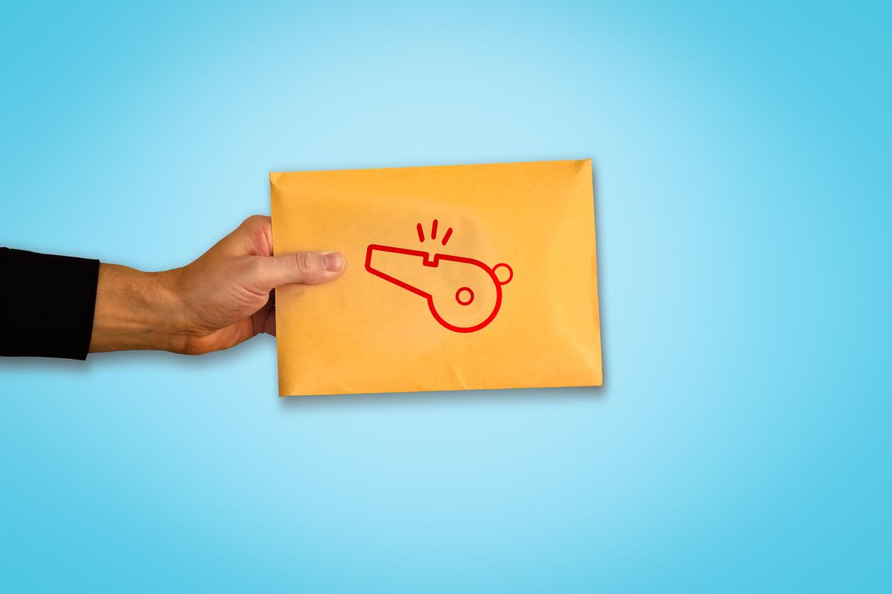 A person holding an envelope full of documents with a whistle stamp on it, symbolizing whistleblower lawsuits